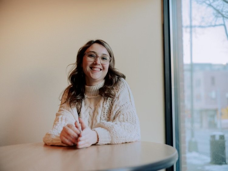 Casey Lynn seated at a table, smiling